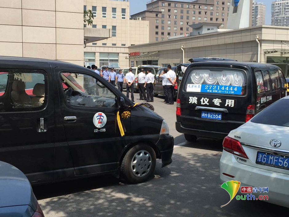 图为天津殡仪专车停在医院住院部门口等待接受遇难者遗体.