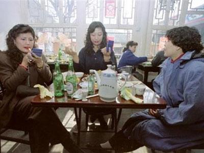 1994年2月25日,北京,妇女在饭店用餐后补妆.