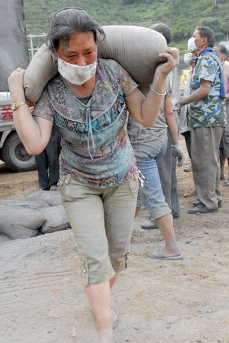 图为一女农民工在扛水泥,一袋水泥,一个青年不一定能扛起了 ,而女农民