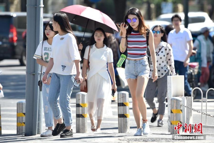街头行人夏装出行. 中新网记者 金硕 摄