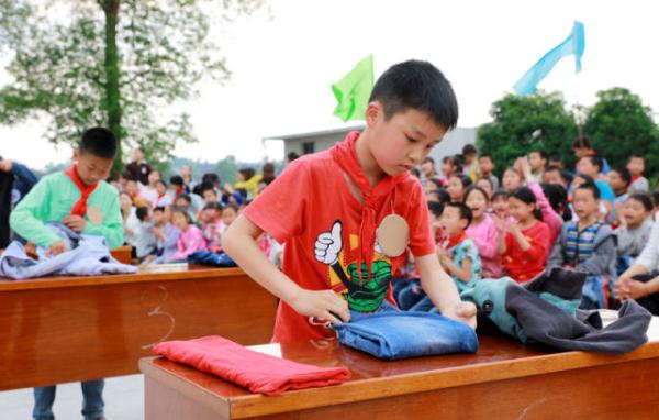 在该校就读的小学生和初一,初二年级学生参加了穿衣服,洗漱,叠衣服