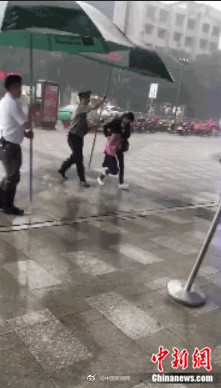 暖心﹗突降大雨 商场保安用遮阳伞为过街母女