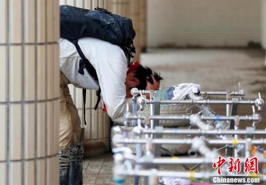 日本民众高温中展开灾区恢复工作 凉水冲头解暑 日本民众高温中展开灾区恢复工作 凉水冲头解暑