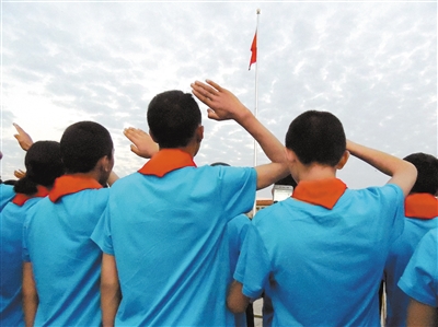 杂多县60名学生望着鲜艳的五星红旗,举起右手敬着少先队礼