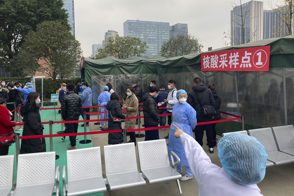 12月9日,在成都市第一人民医院,人们有序排队接受核酸检测.