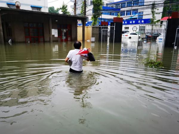 22日7时,新乡市气象局局长申安喜冒雨涉水赴市政府参加新闻发布会.