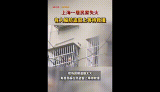 一居民家失火，有人躲到防盗窗上等待救援......
