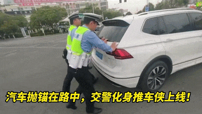 轿车抛锚路中间 交警化身“推车侠”