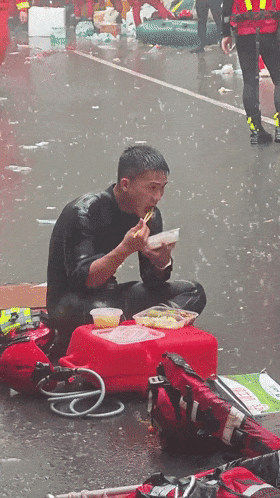 他席地而坐,在雨中吃饭!本人回应 他席地而坐,在雨中吃饭!本人回应