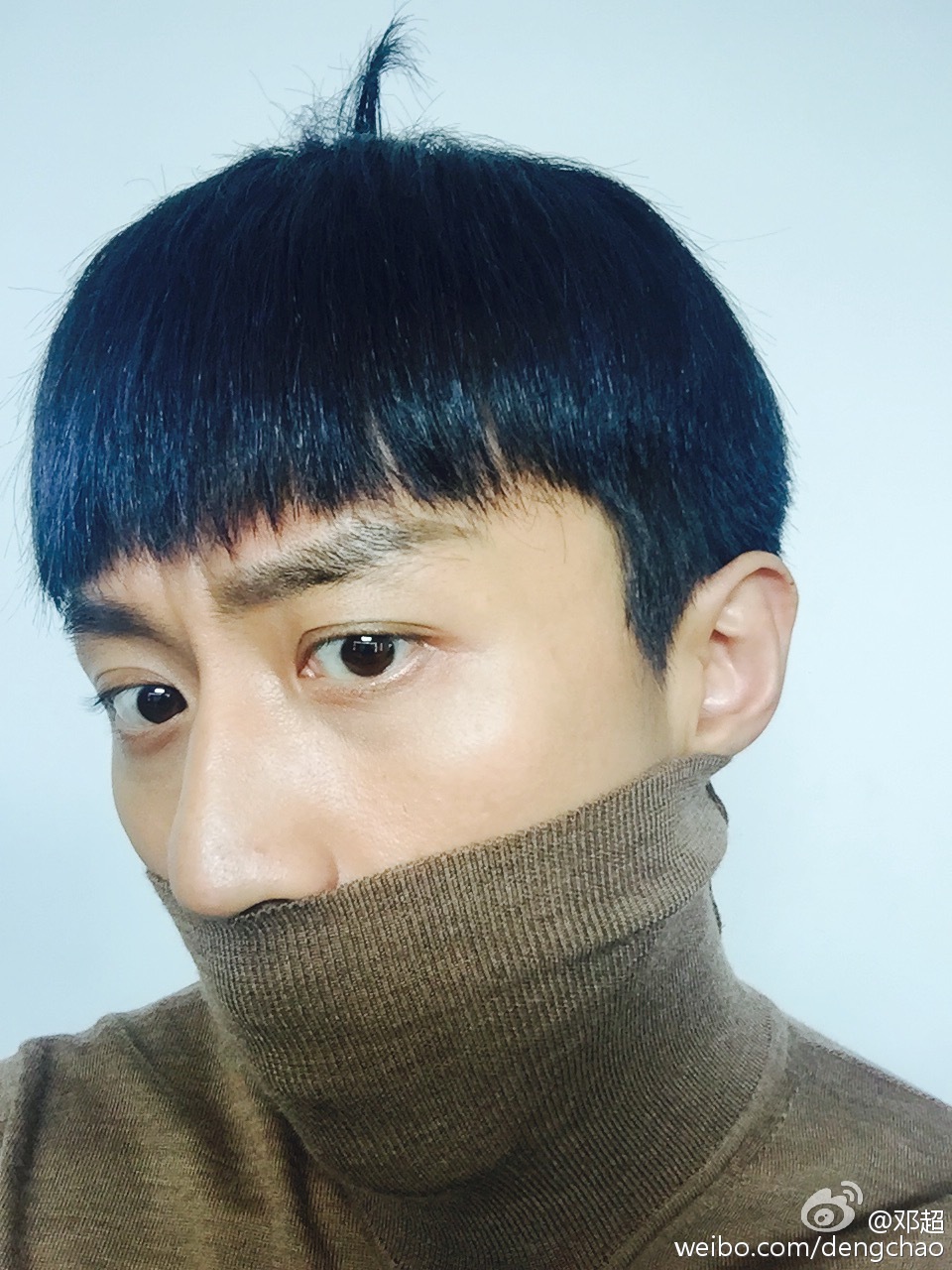 照片中,邓超身穿高领上衣,还用领子挡住鼻子和嘴巴,头顶几根头发竖