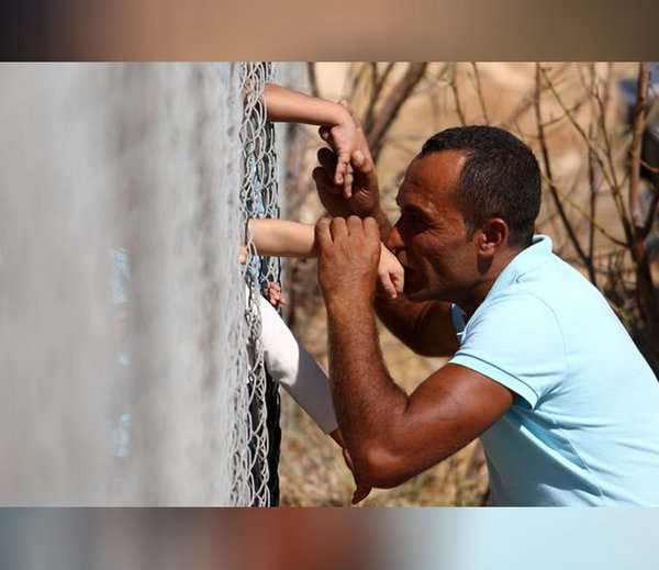 叙利亚父亲一年后终于见到自己儿子 隔着铁丝网亲吻