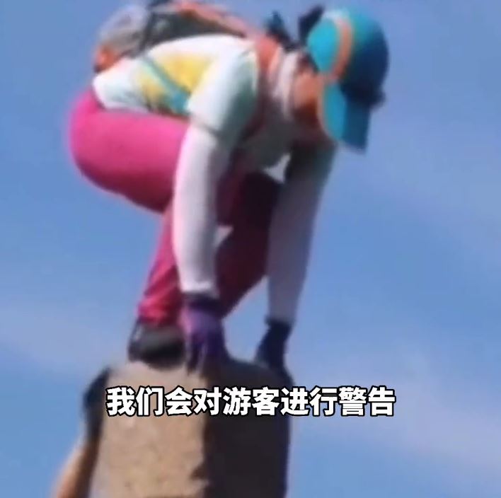 大妈爬上山顶石柱“金鸡独立”拍照 网友：用生命摆造型？