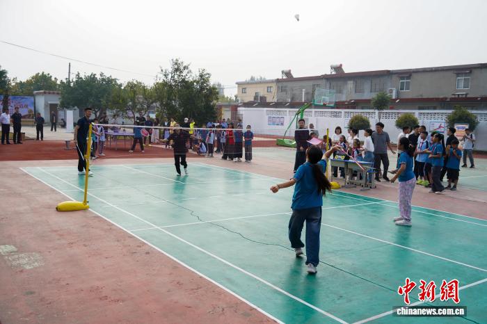 河南新乡:乒羽冠军进校园 与学生互动打球