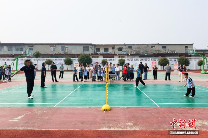 河南新乡:乒羽冠军进校园 与学生互动打球