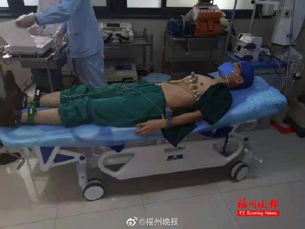 照片里,一名男医生躺在病床上,身上戴着心电图的设备