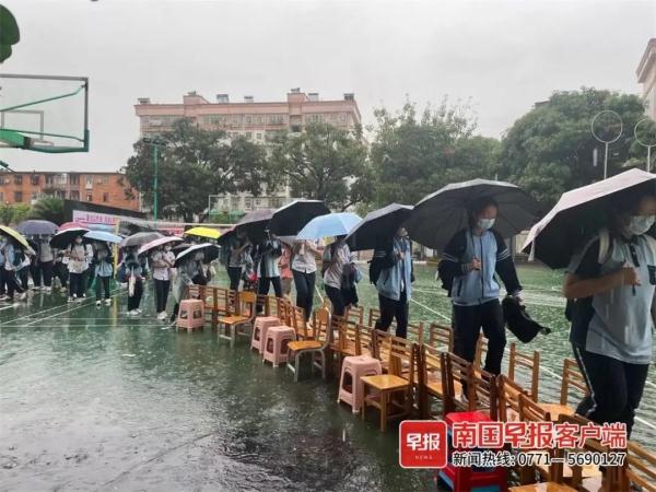 点赞！南宁一学校老师雨中赤脚蹚水，用凳子为学生搭桥