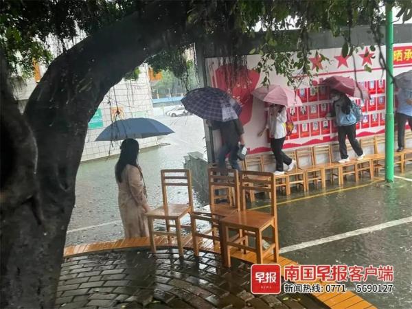 点赞！南宁一学校老师雨中赤脚蹚水，用凳子为学生搭桥