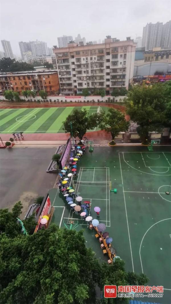 点赞！南宁一学校老师雨中赤脚蹚水，用凳子为学生搭桥