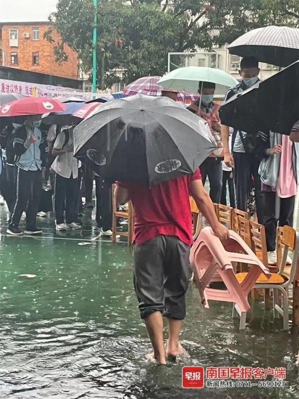 点赞！南宁一学校老师雨中赤脚蹚水，用凳子为学生搭桥