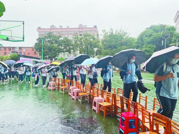 暖心！南宁一学校教师雨中为学生搭起“板凳桥”