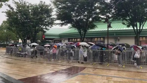 上海迪士尼部分恢复运营，游客冒雨排队进商店，不少人买了星黛露