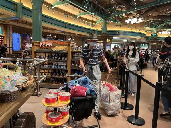 上海迪士尼部分恢复运营，游客冒雨排队进商店，不少人买了星黛露
