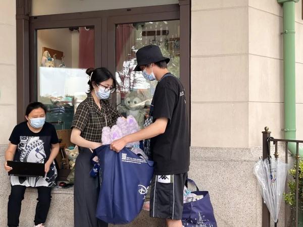 上海迪士尼部分恢复运营，游客冒雨排队进商店，不少人买了星黛露