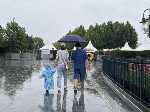 上海迪士尼部分恢复运营，游客冒雨排队进商店，不少人买了星黛露