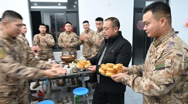 烈士肖思远父母到小儿子连队过年，行李箱里放着一张照片