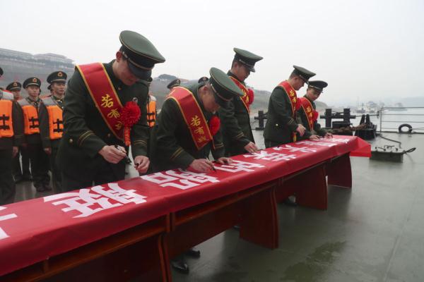 图为武警重庆总队船艇支队退伍老兵在横幅上留下签名.
