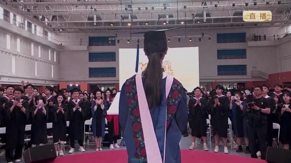 这位中传毕业生被搀扶上台发言，同学们起立鼓掌