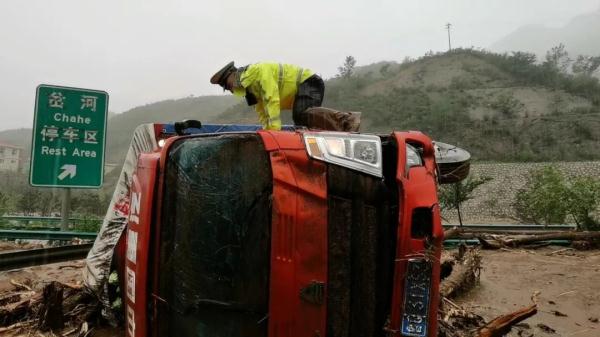 民警趟过齐腰的泥沙，爬上车顶、敲碎玻璃......