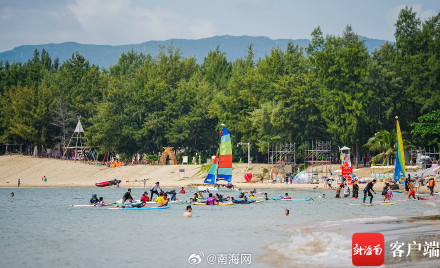 三亚后海迎来众多游客看海冲浪