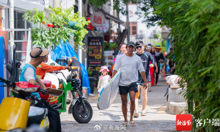 三亚后海迎来众多游客看海冲浪