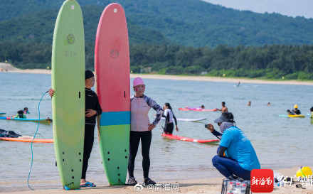 三亚后海迎来众多游客看海冲浪