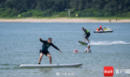 三亚后海迎来众多游客看海冲浪