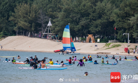 三亚后海迎来众多游客看海冲浪