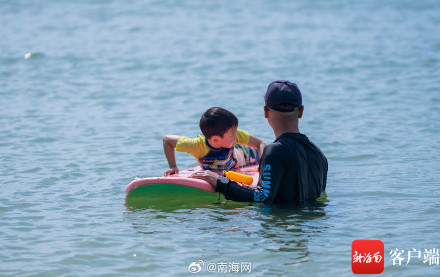 三亚后海迎来众多游客看海冲浪