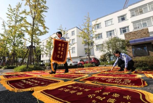 啥派出所啊！锦旗摆了一停车场