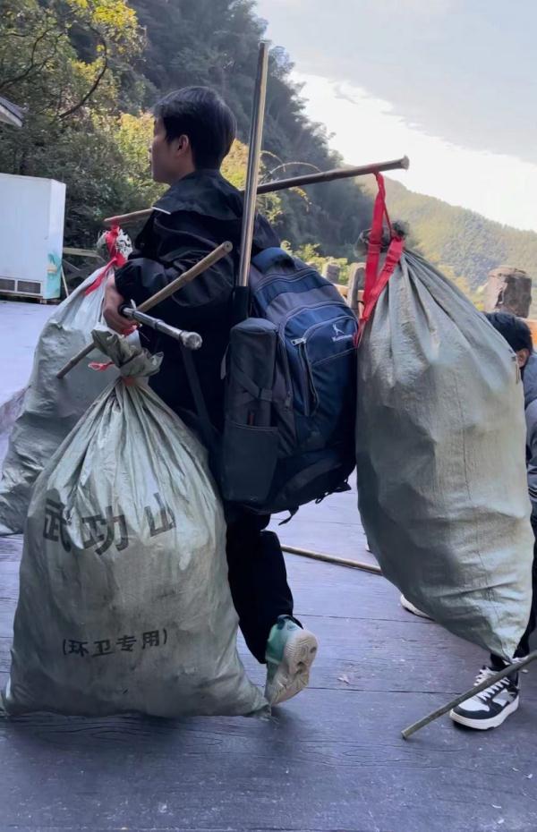 长沙大学生三次夜爬武功山捡800个瓶子挑下山，所带旗子上的文案亮了