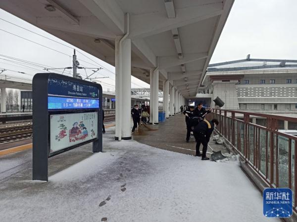 2月1日,淮南西站管内寿县站职工在清扫站台积雪.