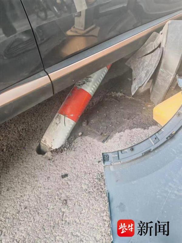 开车捡手机致方向跑偏，小轿车撞上隔离护栏被卡住