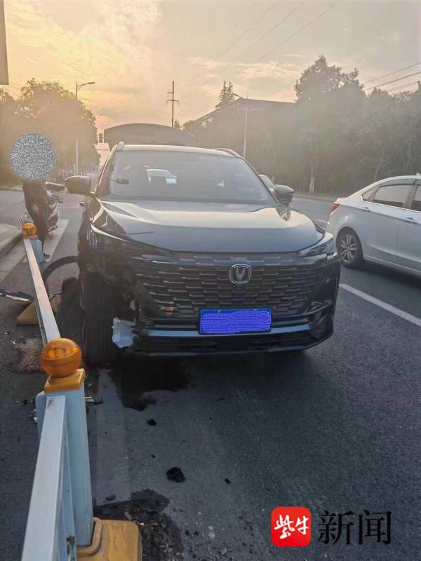 开车捡手机致方向跑偏，小轿车撞上隔离护栏被卡住
