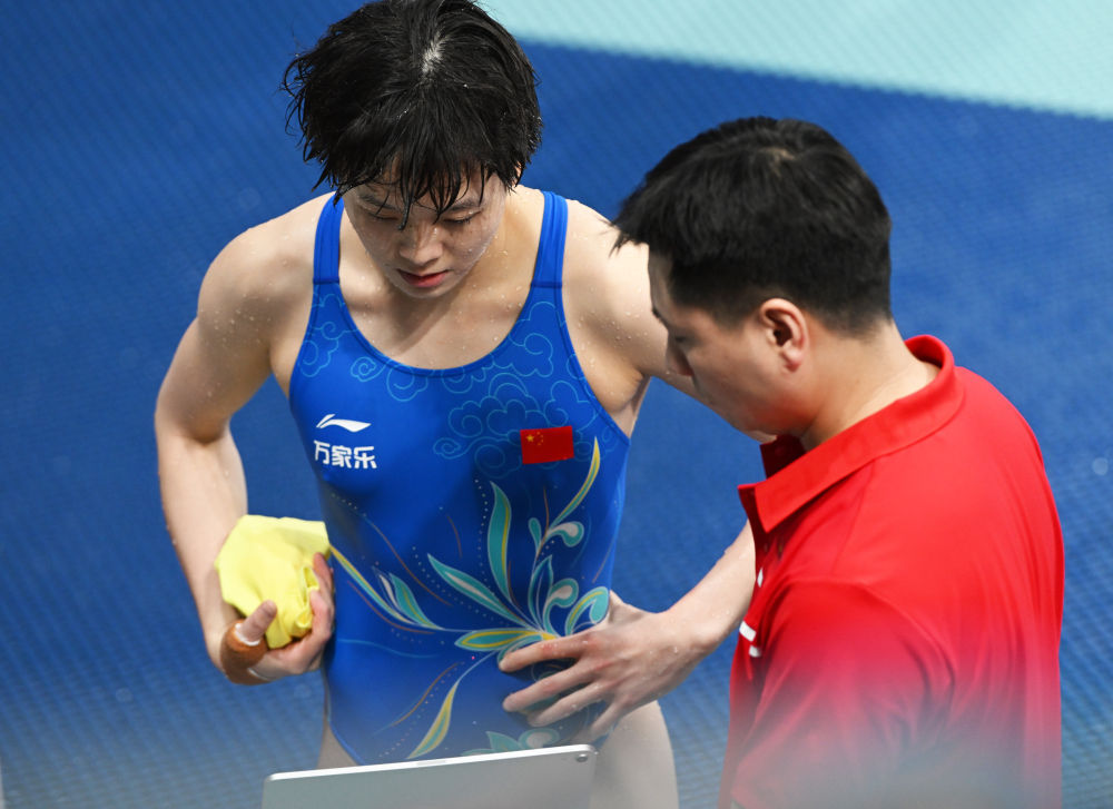 在颁奖仪式后展示印有好友,中国跳水运动员陈艺文和昌雅妮图像的服装