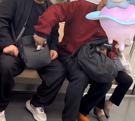 男子在地铁车厢内乱丢果皮，邻座大哥捡起塞回对方包里