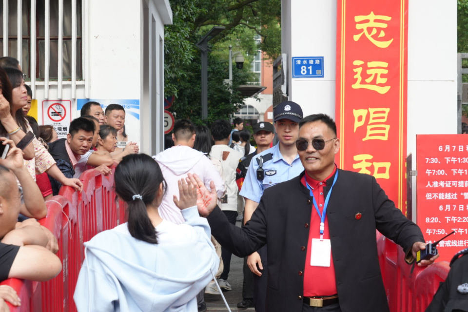 长沙市一中保卫科科长手心写“加油”，校门口迎接每位考生