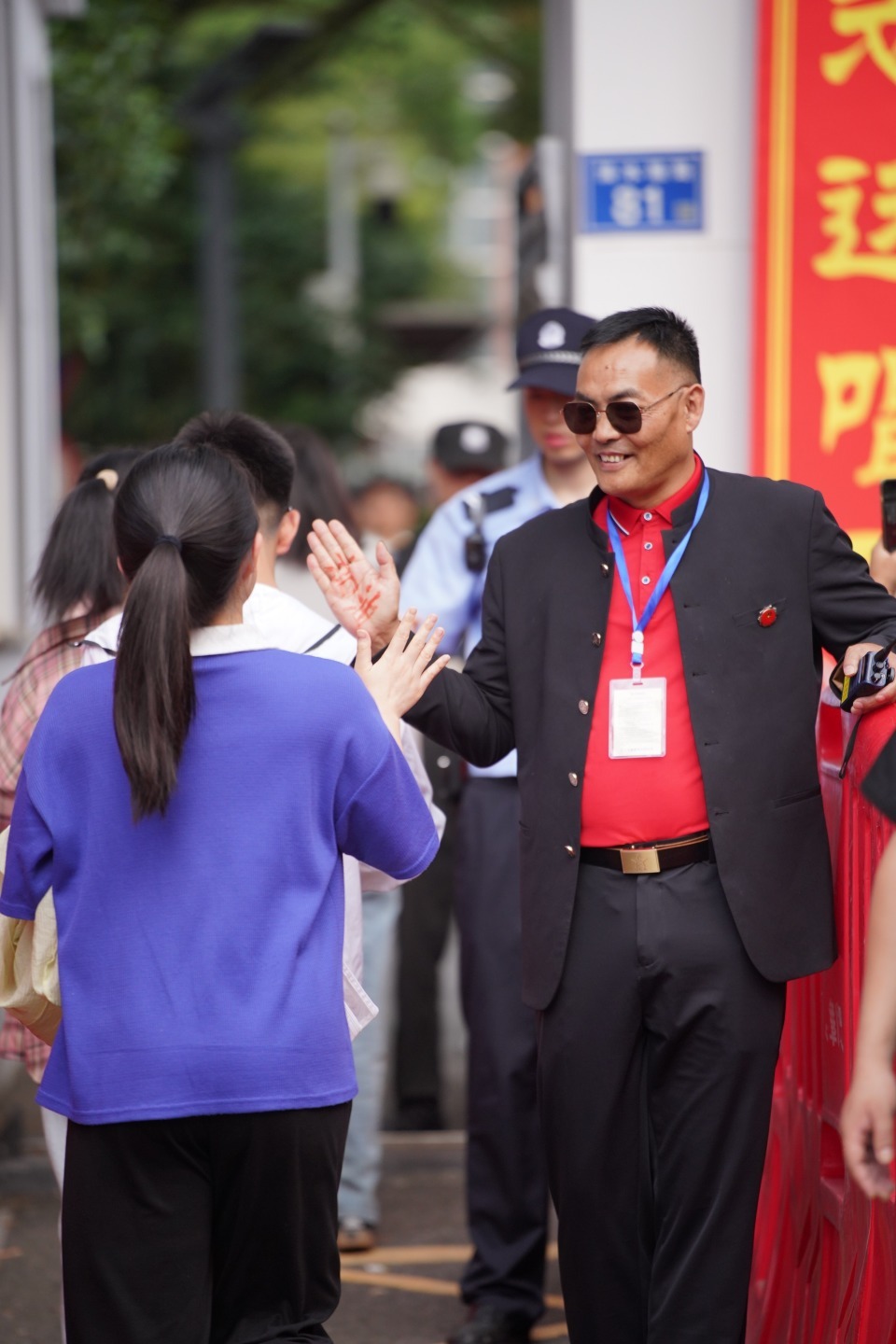 长沙市一中保卫科科长手心写“加油”，校门口迎接每位考生