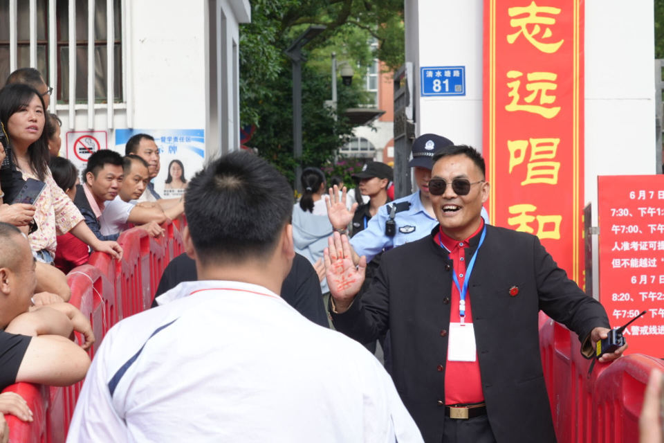 长沙市一中保卫科科长手心写“加油”，校门口迎接每位考生