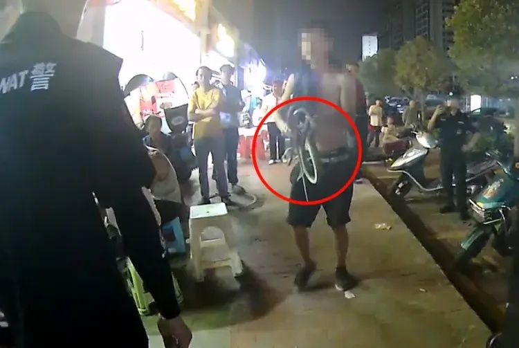 男子当街遛蛇，被行拘5日