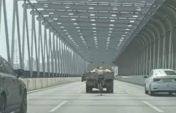 上海高架路惊现一赤膊男子紧贴工程车骑行，市民：已不止一次！